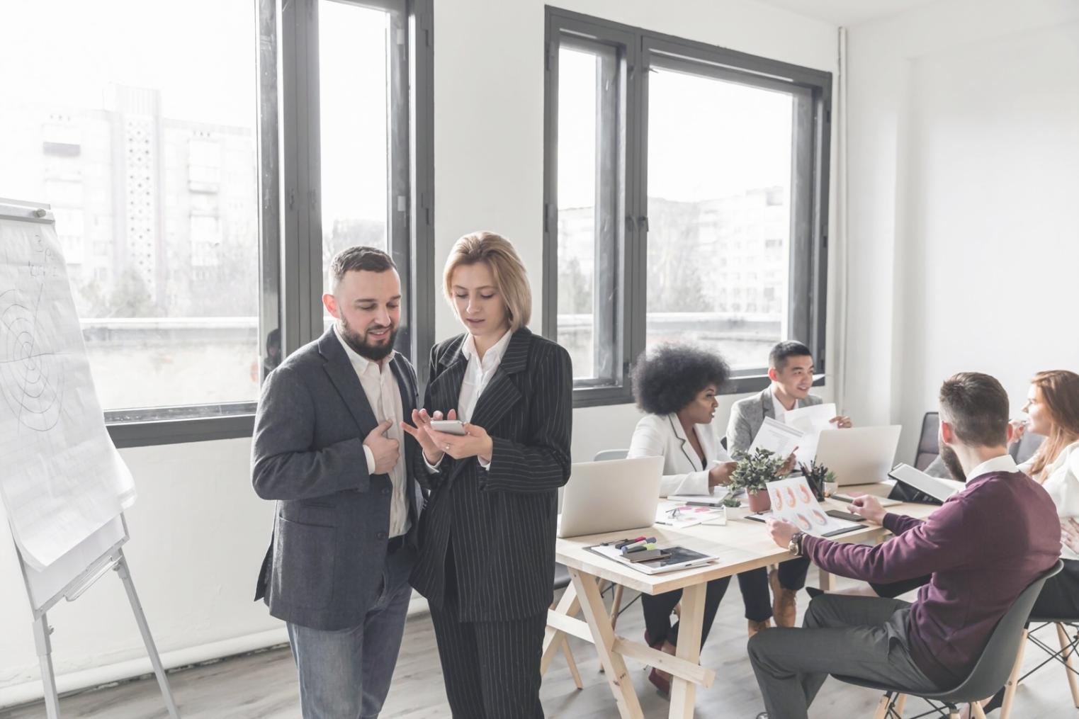 Profesionales analizando gráficos financieros y datos de mercado en un entorno de trabajo colaborativo